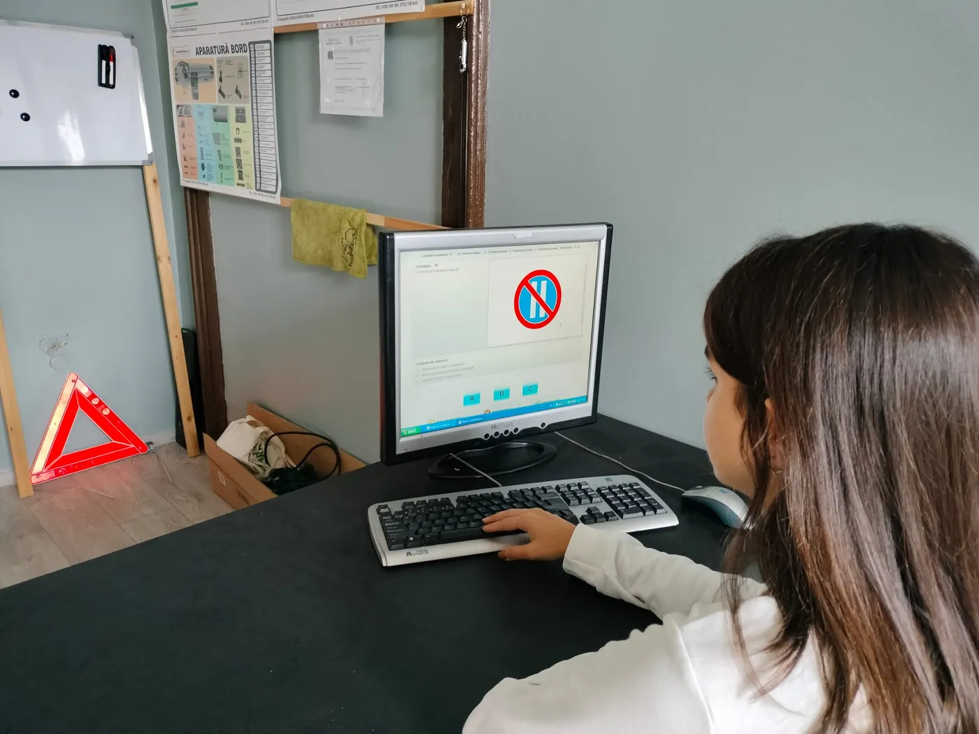 Cursantă la calculator, în sala de pregătire