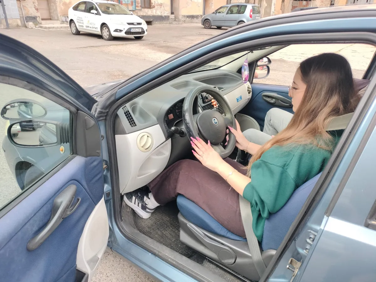 Cursantă la volanul mașinii de școală, înainte de lecție