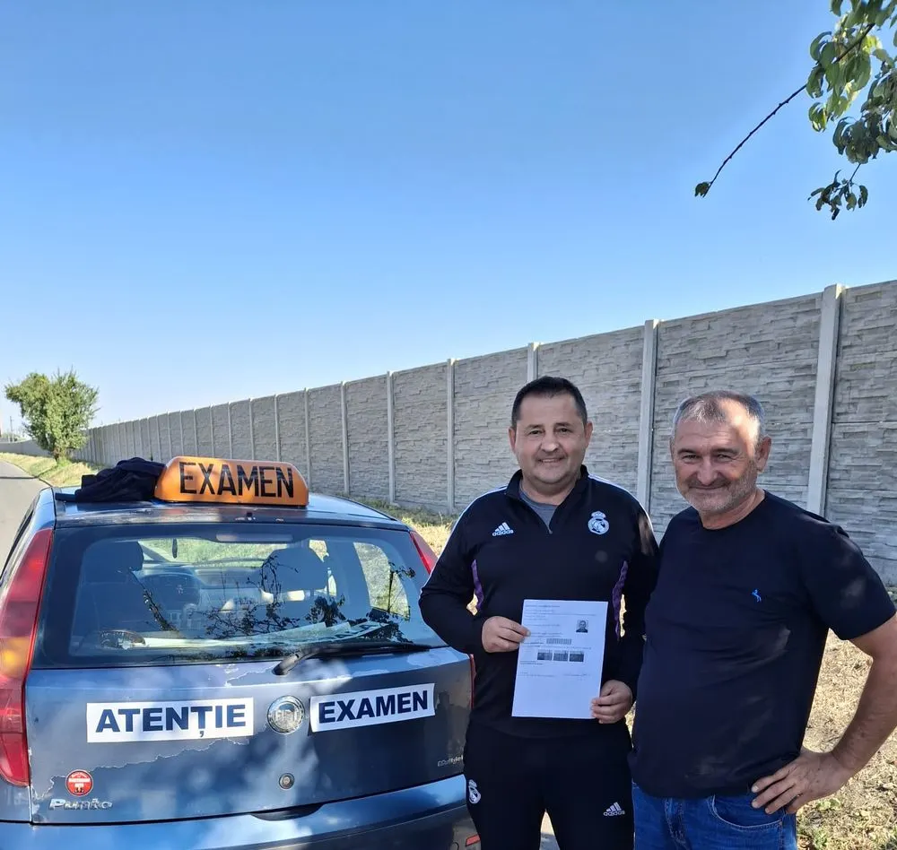 Doi bărbați lângă mașina cu semnul de examen